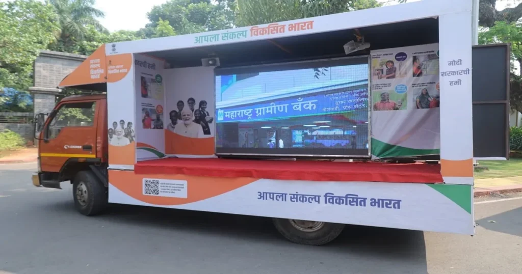 विकसित भारत संकल्प यात्रा 2023-24: उद्देश्य, आँकड़े और 2047 का विज़न | Detailed Guide आईईसी वैन गाँव में योजनाओं की जानकारी देती हुई