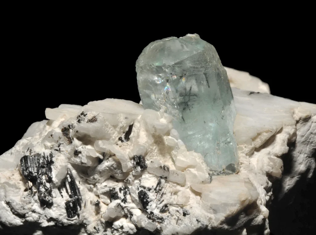 4 Crystals and Crystallization Light blue aquamarine (beryl), black tourmaline with light colored orthoclase. The specimen is from Namibia.