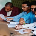 A student anxiously checking their laptop for the JEE Main 2026 Session 2 city intimation slip download link.