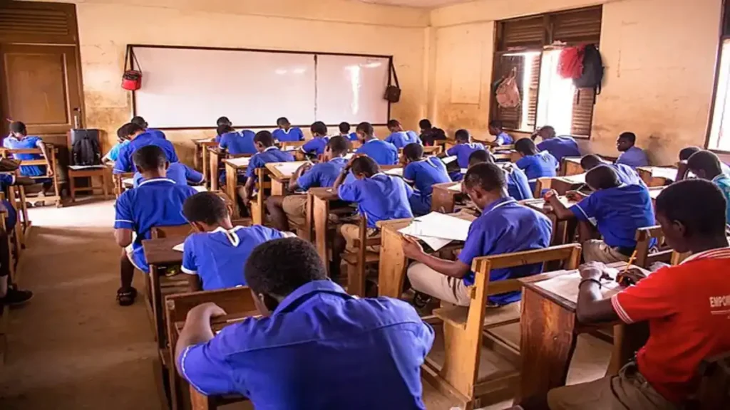 A student concentrating while writing the AP SSC Maths board exam 2026 in an examination hall.