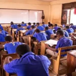 A student concentrating while writing the AP SSC Maths board exam 2026 in an examination hall.