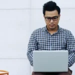 A focused engineering student looking at the GATE COAP 2026 schedule on a laptop screen with the StudyHub logo visible.