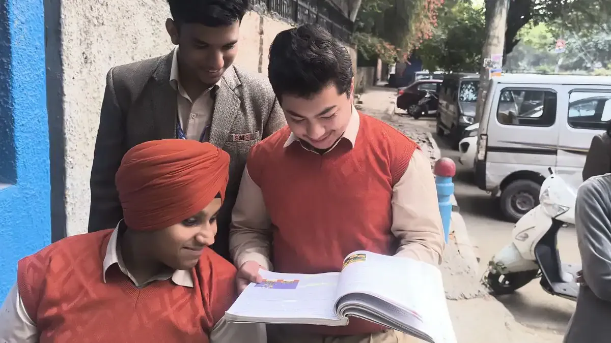 Students looking thoughtful while writing the Maharashtra Board SSC Class 10 Geography exam in a well-lit examination hall.