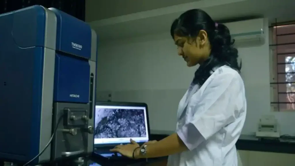 A medical student in a white coat studying in a modern university library, representing the increase in Jharkhand medical seats.