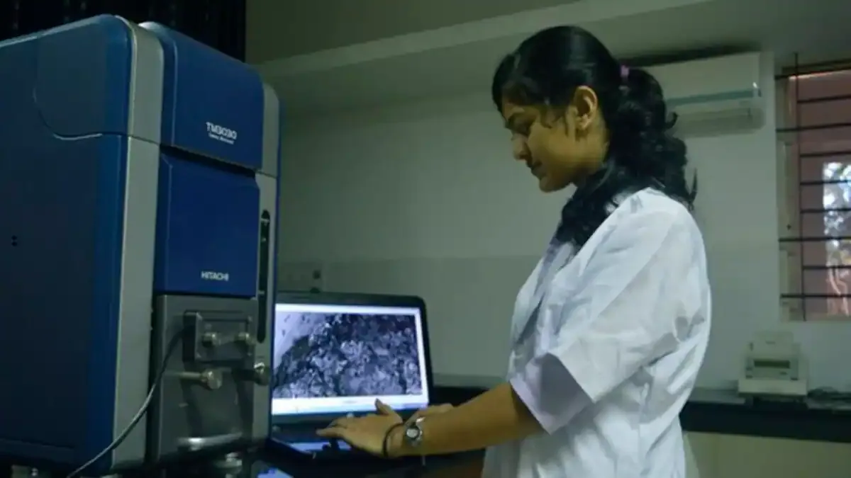 A medical student in a white coat studying in a modern university library, representing the increase in Jharkhand medical seats.