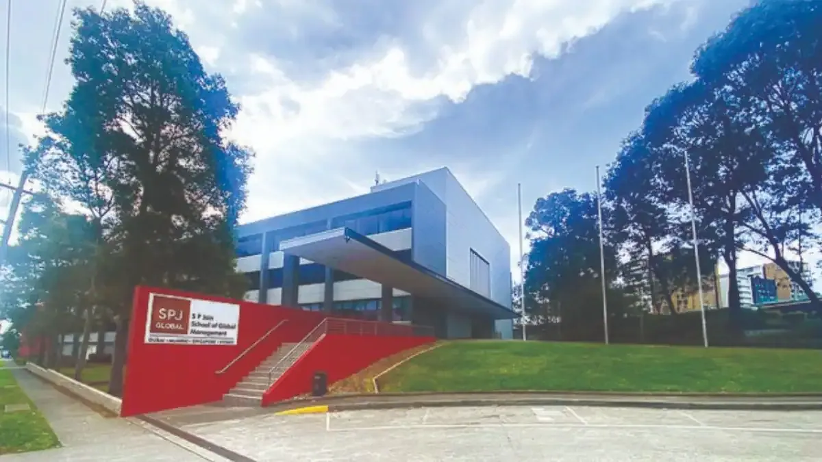 A diverse group of postgraduate students collaborating on a project in a modern classroom at a Sydney university campus.