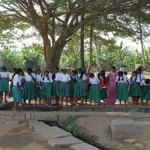 A school hallway with a sign pointing towards the girls' restroom and a health and wellness center, symbolizing the new menstrual health initiative.
