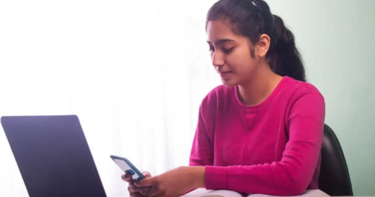 A student focused on their computer screen during the BITSAT 2026 slot booking process, with the official BITS Pilani website visible.