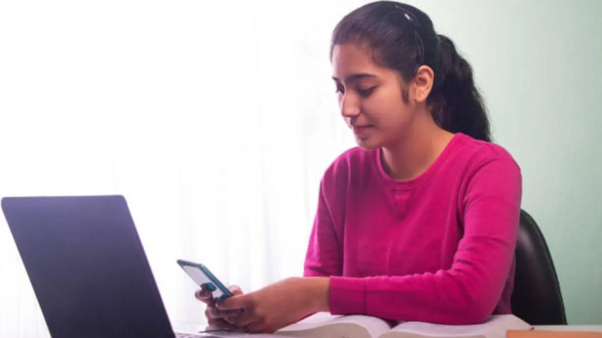 BITSAT 2026 Slot Booking Live! Book Your Exam Date Now A student focused on their computer screen during the BITSAT 2026 slot booking process, with the official BITS Pilani website visible.