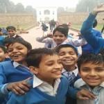 A student smiling while checking the JNVST Class 6 Result 2026 on a laptop screen with the StudyHub logo visible.