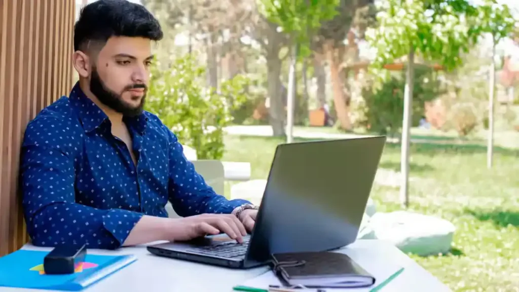 A student looking at their GATE 2026 Result on a laptop screen, feeling happy and successful.