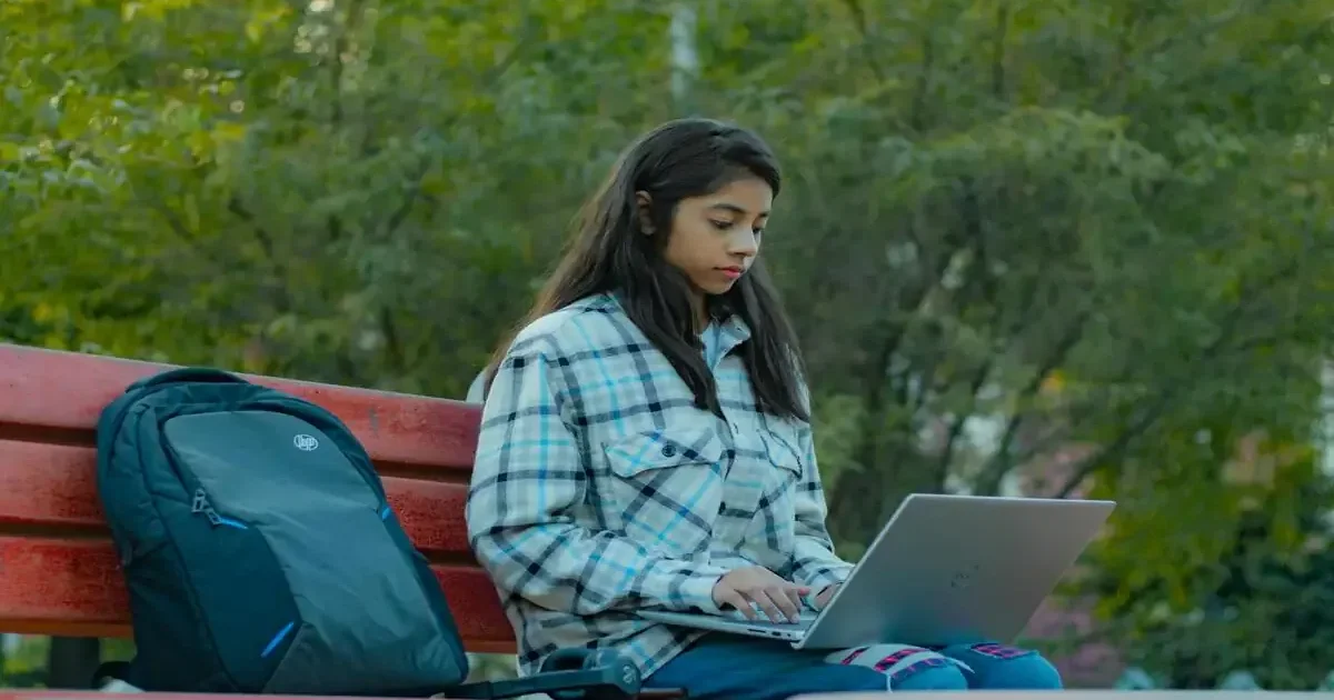 A student looking at their NIOS On-Demand Exam results on a laptop screen, feeling relieved and happy.