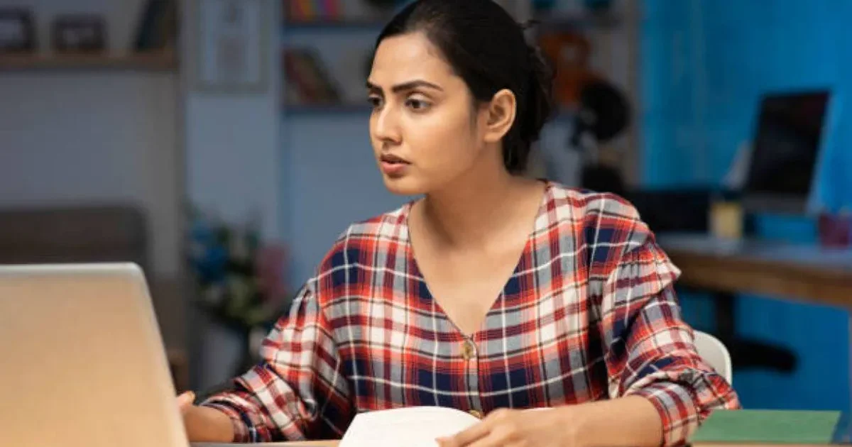 A stressed student looking at a laptop screen displaying a login error for BITSAT 2026 slot booking.