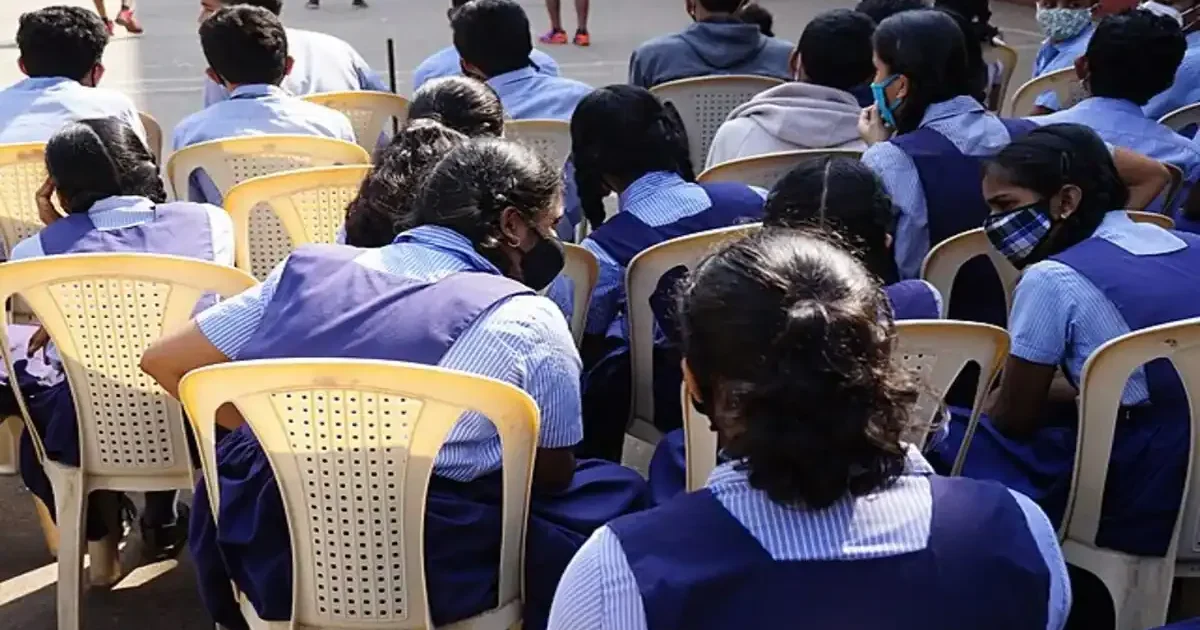 Gurugram police officers and a bomb disposal squad vehicle outside a school building during a security check.