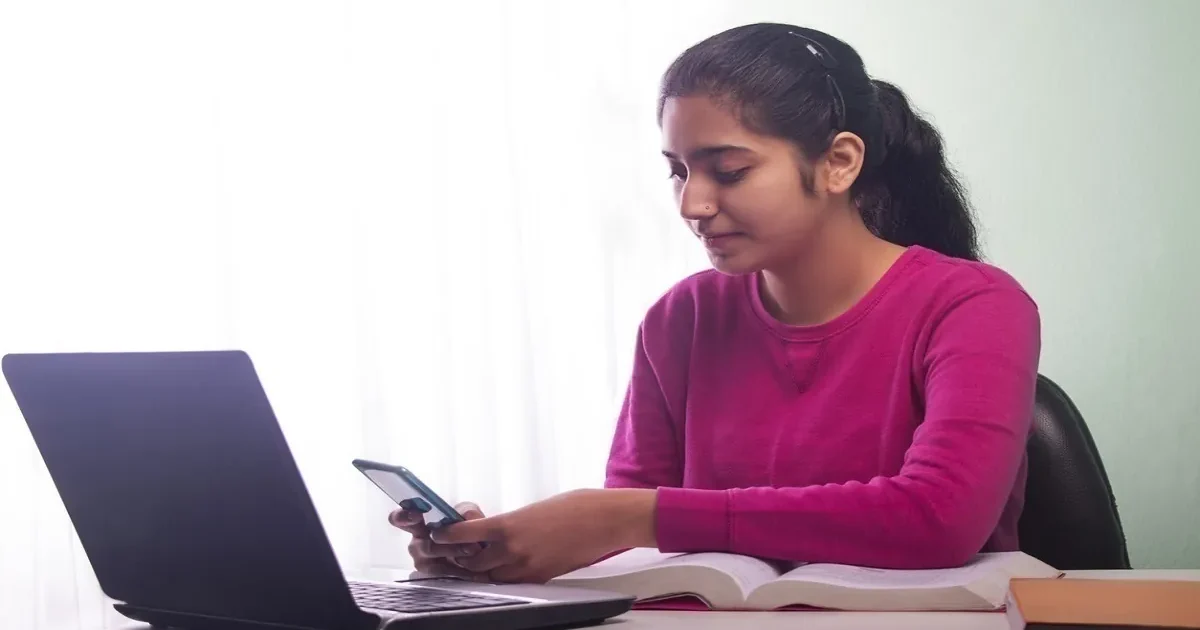 A student focused on their computer screen, completing the MET 2026 slot booking process online for the engineering entrance exam.