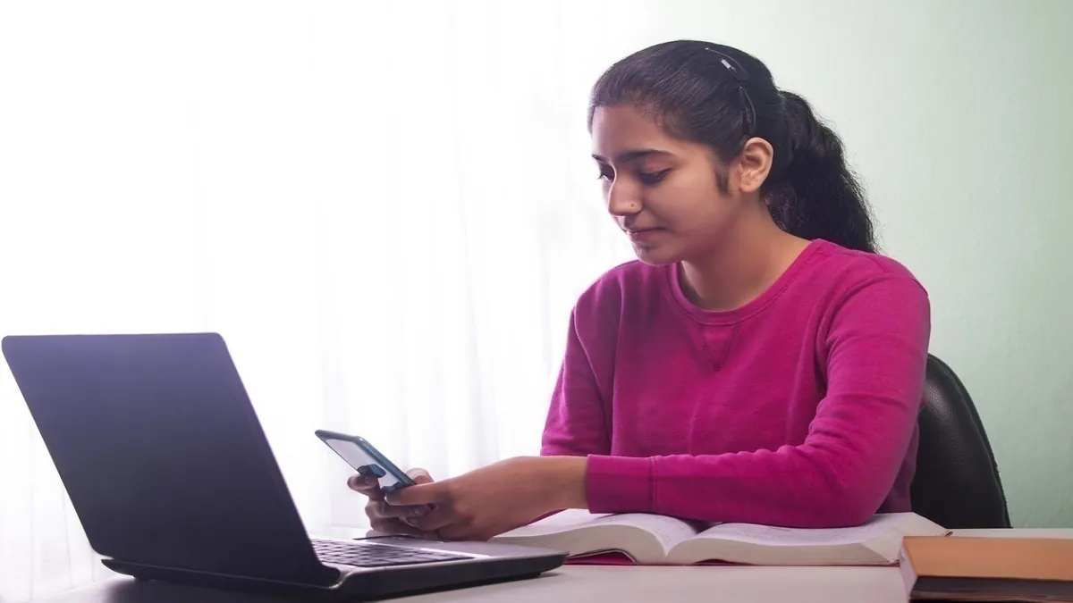 A student focused on their computer screen, completing the MET 2026 slot booking process online for the engineering entrance exam.