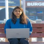A student anxiously checking the StudyHub website on a laptop for the JEE Main 2026 Session 2 city intimation slip update.