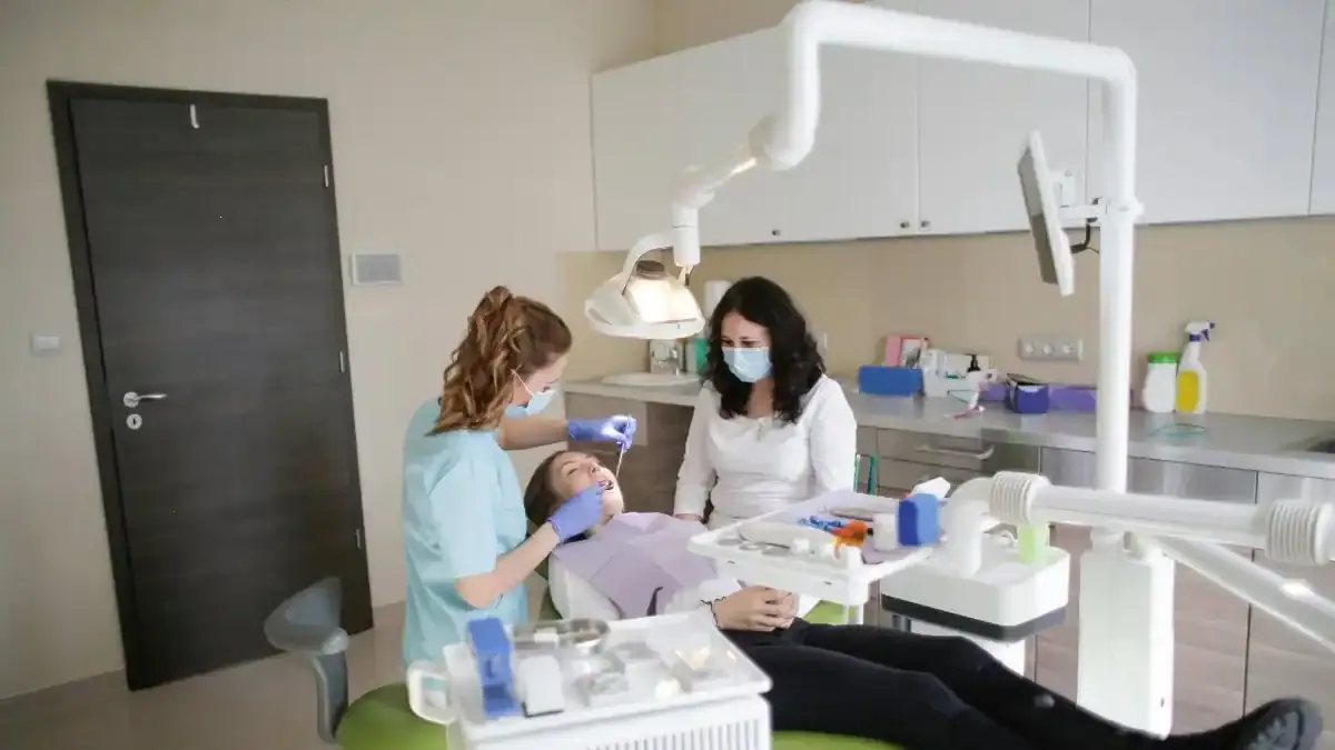 A dentist examining a patient's teeth in a modern, well-lit clinic, symbolizing the new era of the National Dental Commission.