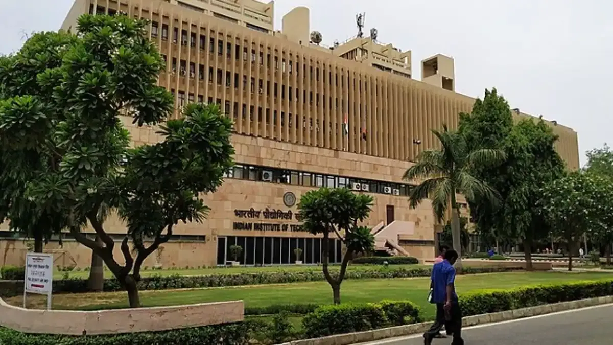 An aerial view of the Indian Institute of Technology (IIT) Delhi campus, showcasing its academic buildings and lush green lawns under a clear sky.