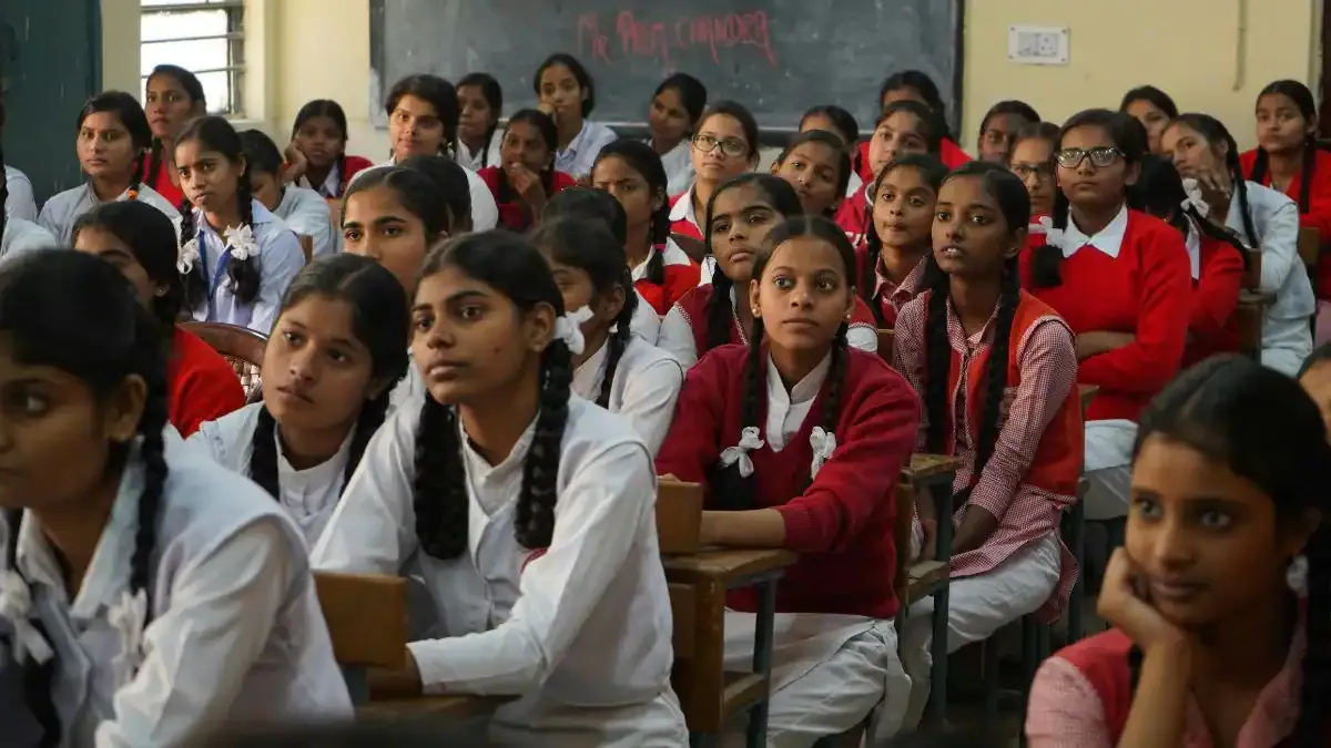 A student diligently studying for the TN Class 12 Biology board exam 2026 with textbooks and diagrams open on their desk.