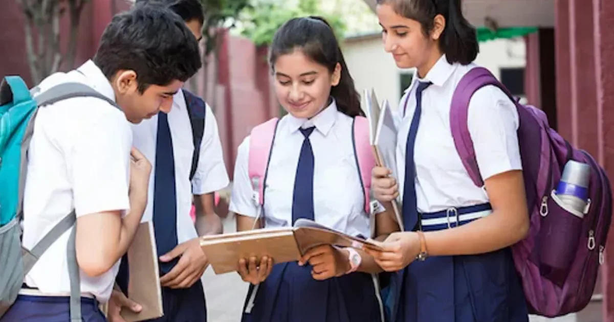 A student anxiously checking their Karnataka PUC I Result 2026 on a notice board at their college campus.