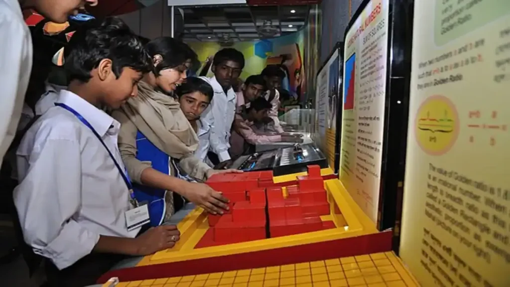 A student marking answers on an OMR sheet for the UP TET 2026 exam, with a calendar showing the application dates in the background.